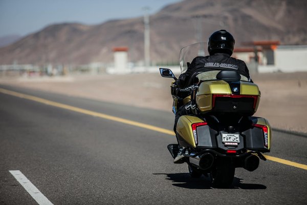 How can you use hand signals to communicate with drivers while riding?